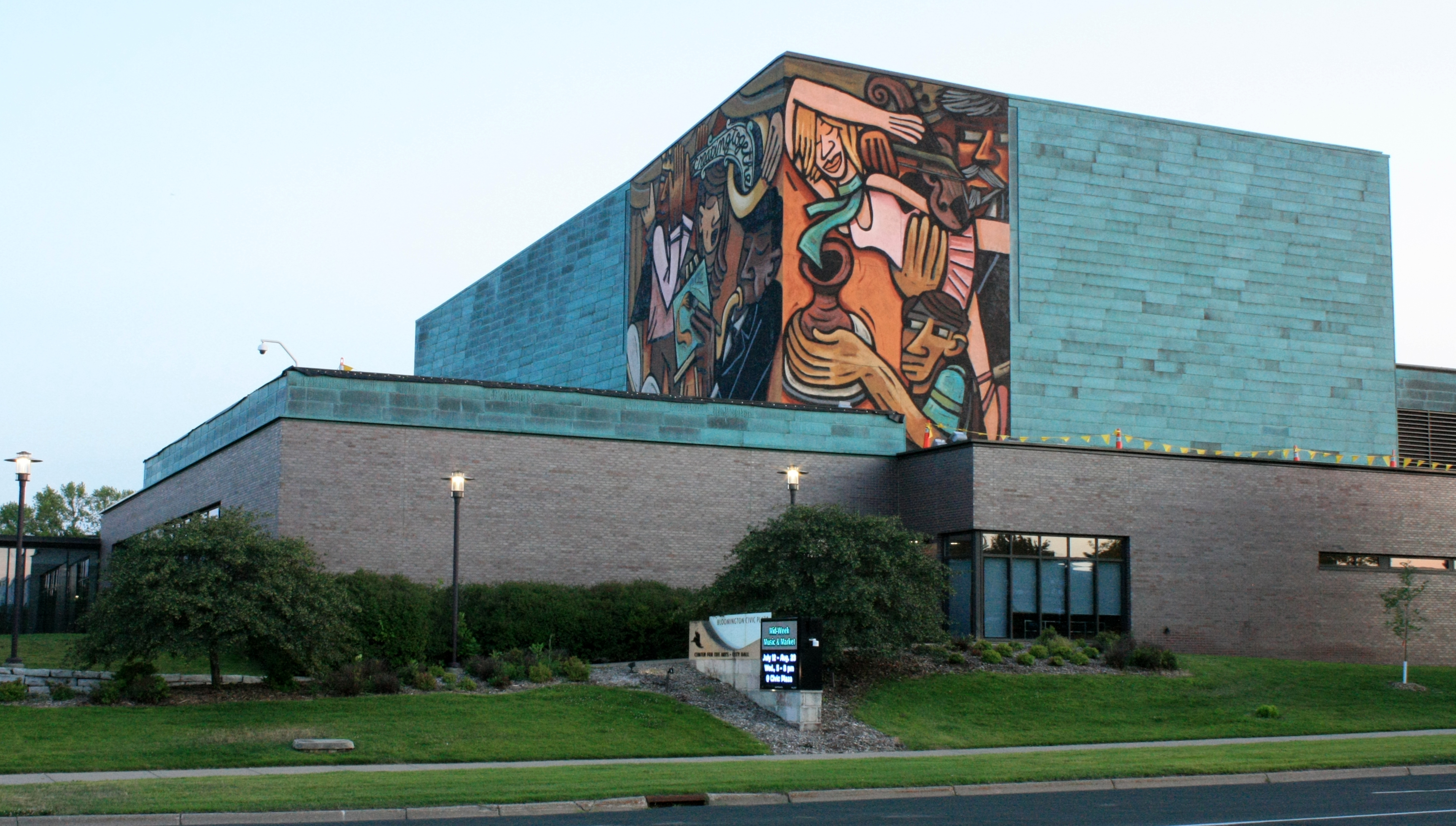 Bloomington Civic Plaza, with a brick facade with a bright blue brick upper level and a colored mural.